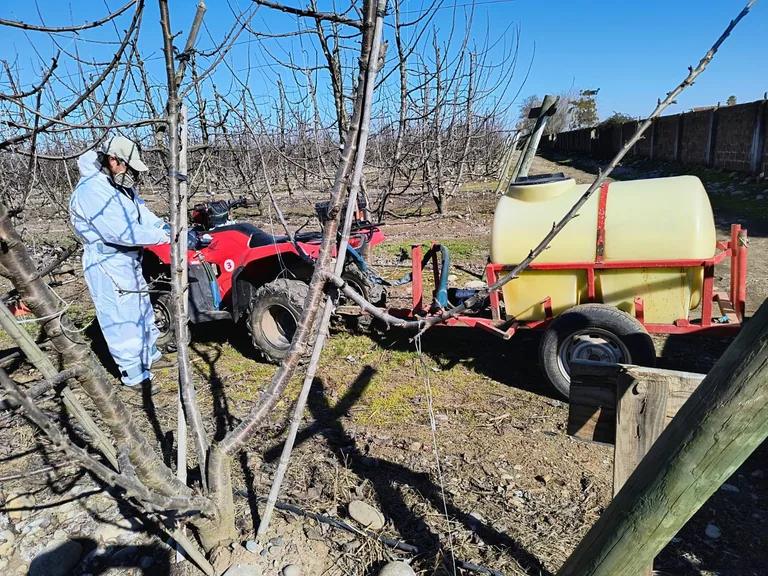 Operador con protección junto a un equipo de aplicación agrícola